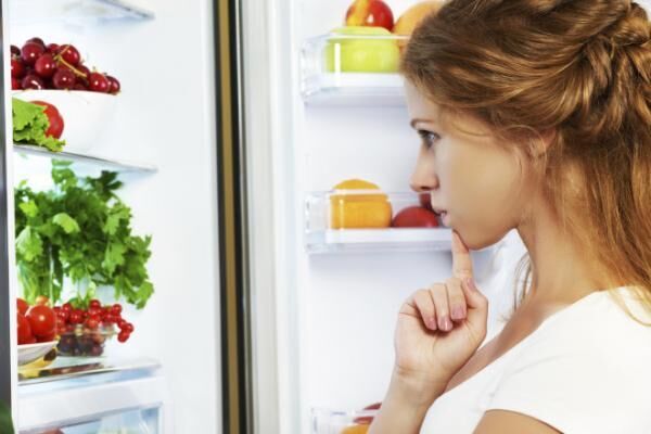 Happy woman and open refrigerator with fruits, vegetables