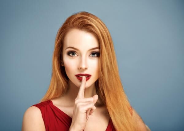 Hush. Sexy Woman with Finger on her Lips.