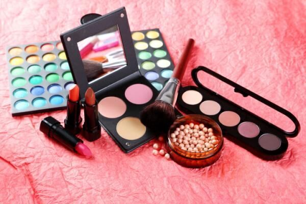 Makeup brush and cosmetics on a red background