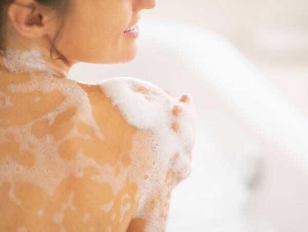 closeup on young woman washing in bathtub. rear view