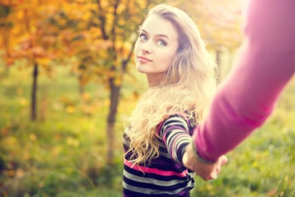 Young Woman Holding Hands on Autumn Background