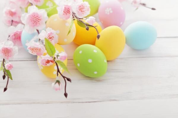 Easter eggs on a white wooden table with cherry blossoms