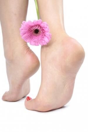 Female feet and flower over white