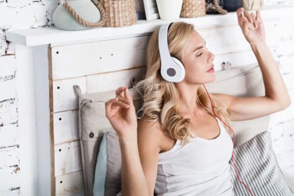 Pretty blond woman listening to music at home