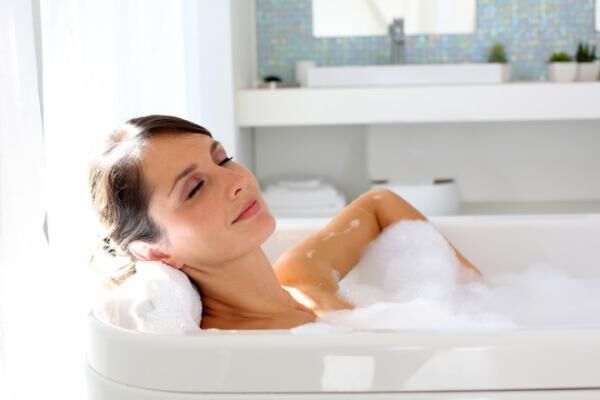 Quiet woman resting in a big bathtub