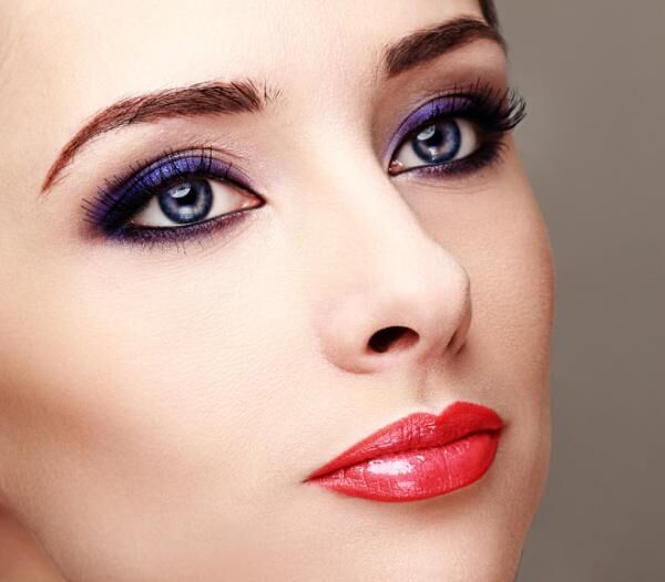 Beautiful woman with bright eyes makeup and long lashes. Closeup