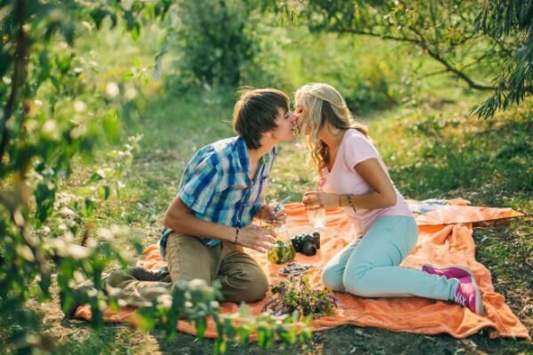 teenage couple kissing on picnic