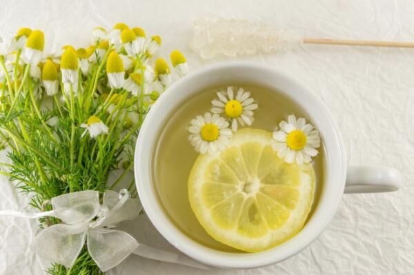 Chamomile tea with lemon slice and flowers