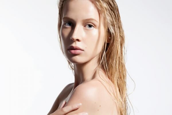 Woman with pure skin and wet hair