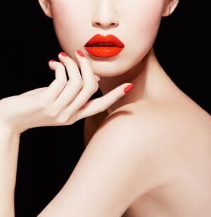 Beautiful makeup. red lips, nail polish manicure.isolated on black.