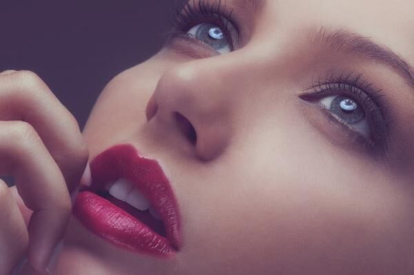 Beauty macro close up of young woman in red lipstick