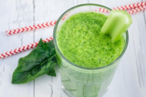 Green smoothie with celery, cucumber, spinach, apple and lemon