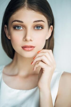 Indoor shot of young beautiful woman on light background