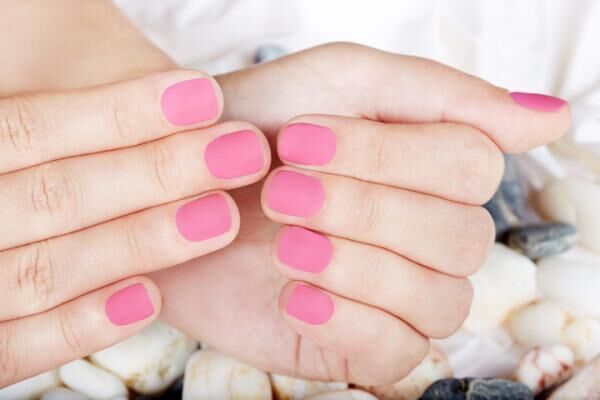Hands with pink matte manicured nails
