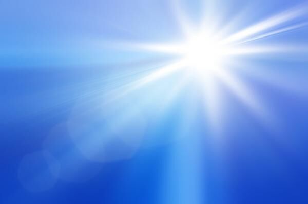 Sun on a blue sky with rays and flare