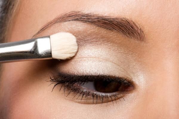 woman applying eyeshadow on eyelid