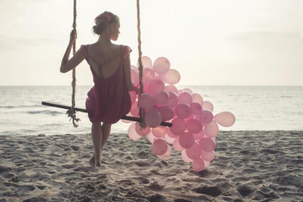 beautiful women at swing with pink ballons