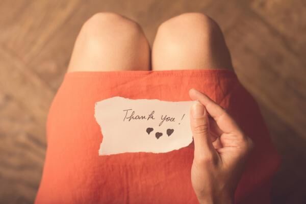 Woman holding a thank you note in her hand