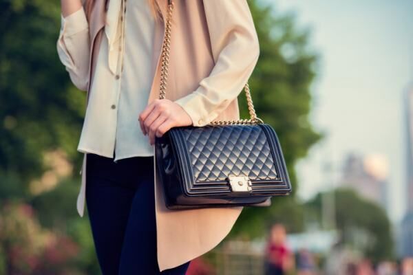Woman carrying elegant purses bag at city park