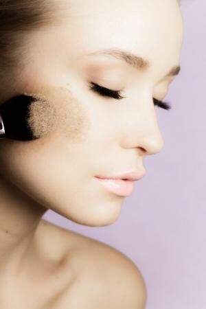 Woman applying face powder, beauty make-up