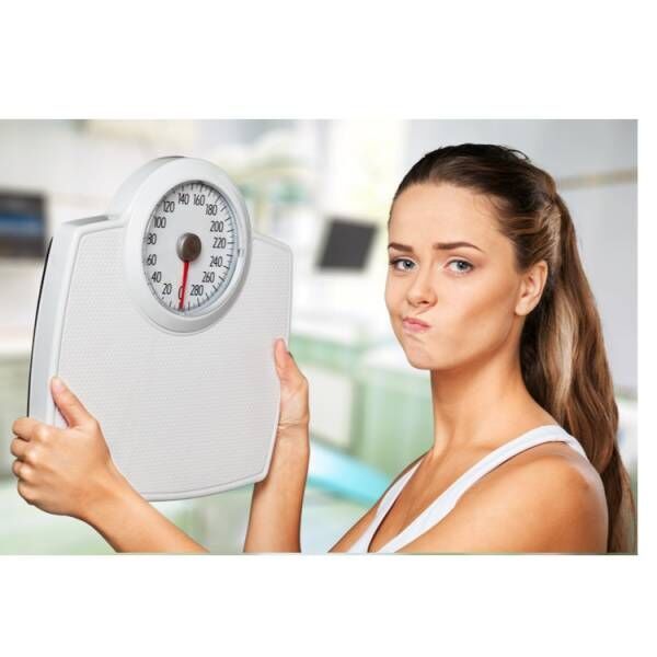 体重計を持つ女性