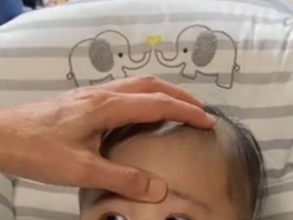 「動いたらやられる…」の顔！　眉間を押さえられた赤ちゃんに反響