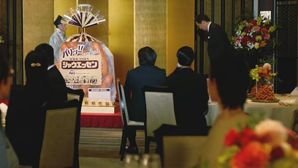 『巨大シャウエッセン』を囲む人々　謎の披露パーティに「お腹抱えて笑った」