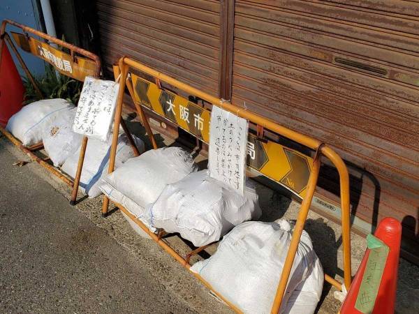 重石の『土のう』が１つだけ変！　貼り紙の内容に「ここまでやる？」「悪いヤツ」