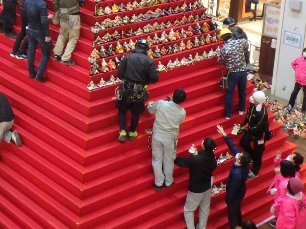 ショッピングモールで作業する人々　人形を１８００体並べると？