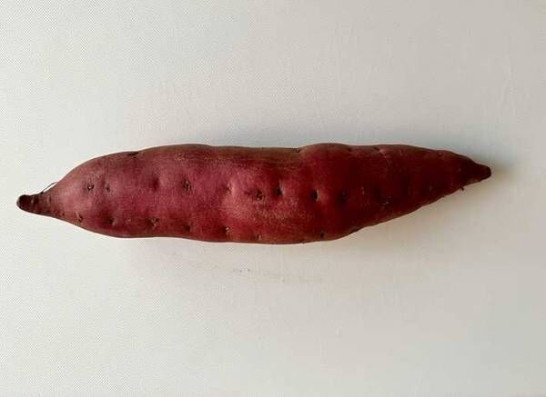 まな板に乗ったサツマイモの写真