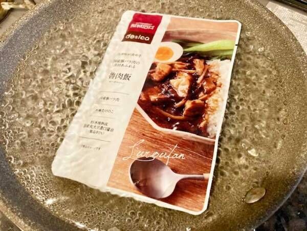 『成城石井ｄｅｓｉｃａ五香粉が決め手国産豚バラ肉の具材あふれる魯肉飯１５０ｇ』の商品写真を湯煎している写真