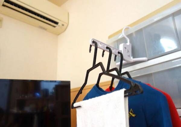 暖房の近くに『室内干しハンガー（５連 角度調整可）』を設置して洗濯を干している写真