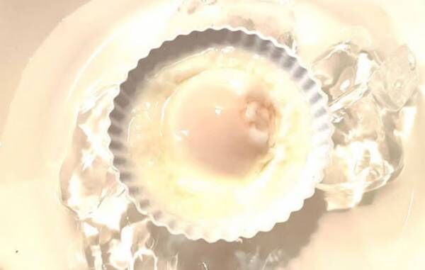 茹であがったカップに入った卵を氷水で冷やしている写真