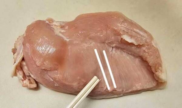 鶏むね肉の繊維の筋の向きを白線で記した写真