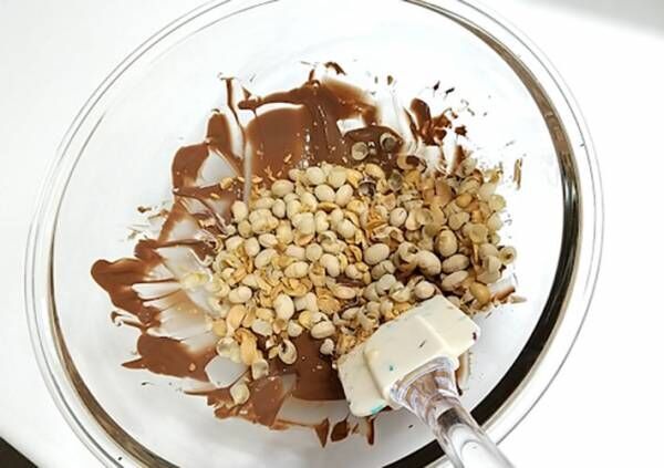 溶かしたチョコレートに砕いた福豆を混ぜ入れている写真