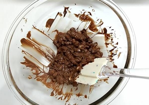 溶かしたチョコレートに砕いた福豆をまんべんなく混ぜ入れている写真