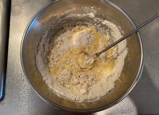 混ぜ合わせた生卵と牛乳に小麦粉を入れた様子