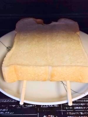 お皿の上の割り箸を乗せた電子レンジでチンしている食パン