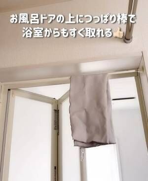 浴室のドア枠につっぱり棒をかけてタオルを干している様子
