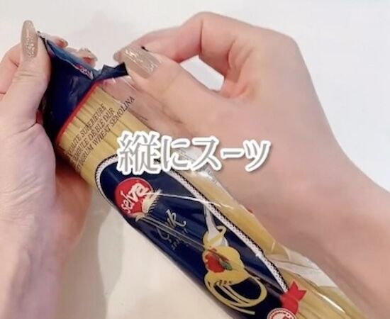 パスタの袋の口を指でつまんで縦に開けようとして売る様子