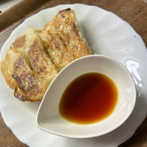 皿の上に盛り付けられた餃子と小皿に入ったレモン醤油