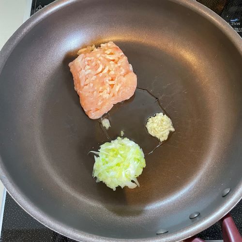 フライパンに鶏ひき肉とニンニクと長ネギを入れた様子