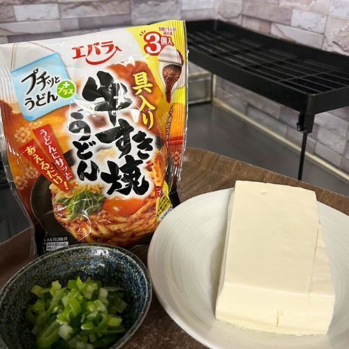 豆腐とネギ、エバラ プチっとうどんプラス 具入り牛すき焼きうどんを並べた写真