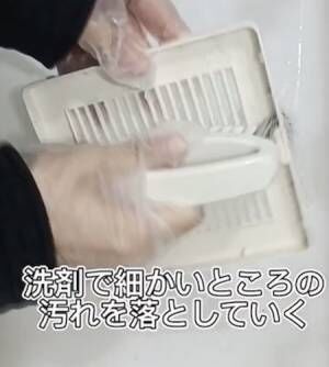 手袋をはめてカバーをブラシでこする様子