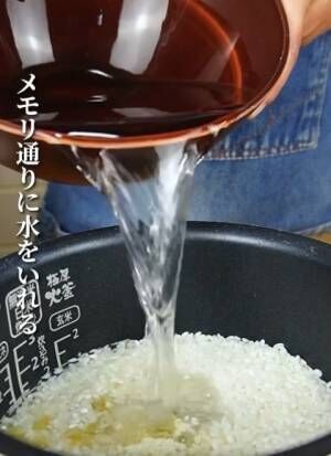 米を入れた炊飯釜に水を入れる様子