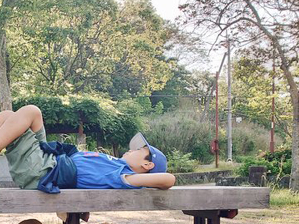 ベンチで寝そべる小学生　下を見ると？　「思わず笑った」「効率よすぎる！」