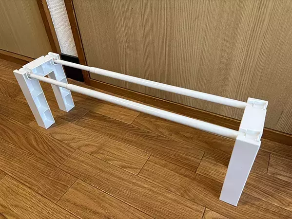 くぼみがある2個の白いパーツ　つっぱり棒と組み合わせると…「これで十分」「家族も喜んだ」