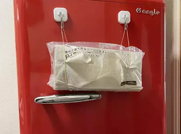 キッチンペーパー、まだ棚に入れてる？　マグネットフックと輪ゴムを合わせる裏ワザに「片手で取り出せる」「つけ替えも簡単」