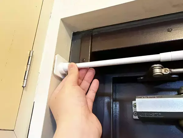 玄関ドア枠の上に『つっぱり棒』を設置するとスッキリ　狭い空間の収納力をアップさせる活用法