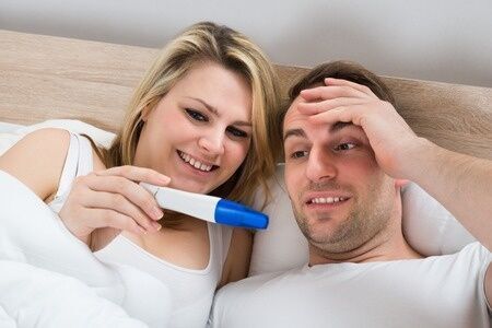 39120304 - couple looking at a positive pregnancy test in bedroom